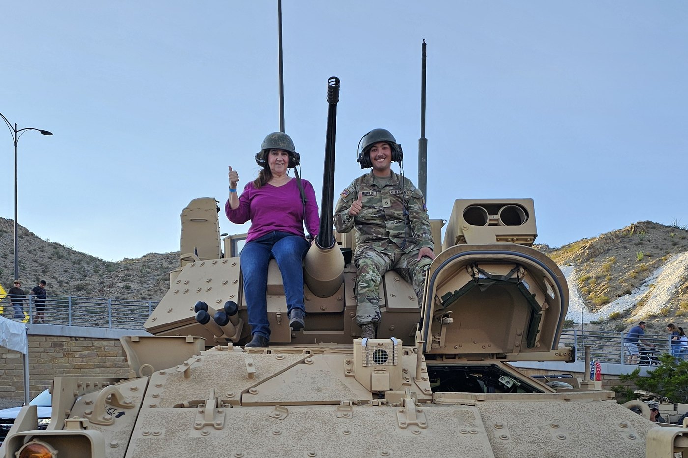 Connie, PHR-certified career success coach at Resume Solutions of El Paso, on a Bradley fighting vehicle with a soldier